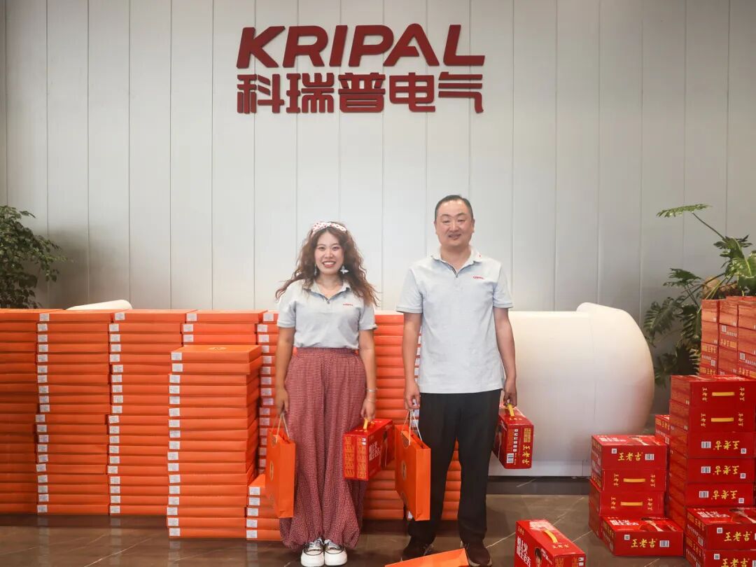 Two KRIPAL Electric employees receiving Mid-Autumn Festival gift bags at the company headquarters